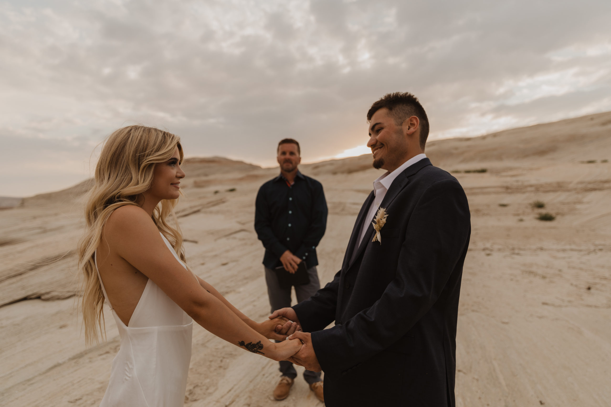 Couple and their officiant in an elopement ceremony on the shore of Lake Powell